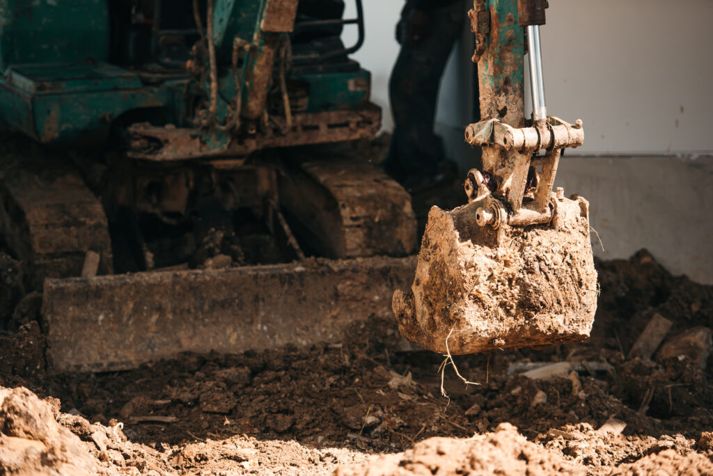 close up worker backhoe working in construction site close up worker backhoe working in construction site